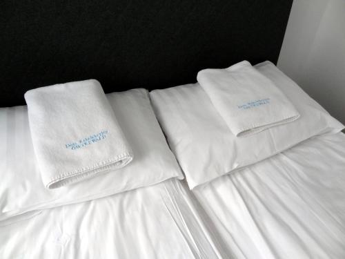 two white towels sitting on top of a bed at DOMUS MARIAE Gietrzwałd in Gietrzwałd