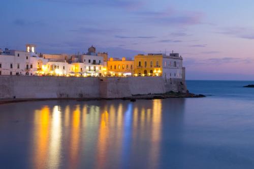a group of buildings sitting on the water at night at B&B Secret Suite in Gallipoli