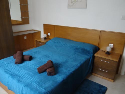 a bedroom with a blue bed with two brown towels on it at Modern Two Bedroom Sea View Apartment in Marsaskala
