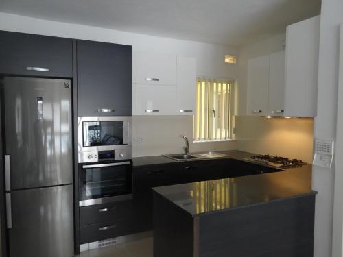 a kitchen with a stainless steel refrigerator and a sink at Modern Two Bedroom Sea View Apartment in Marsaskala