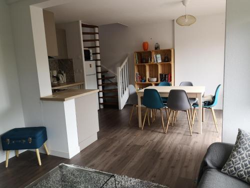 - une salle à manger et une cuisine avec une table et des chaises dans l'établissement Les baigneurs, à Merville-Franceville-Plage