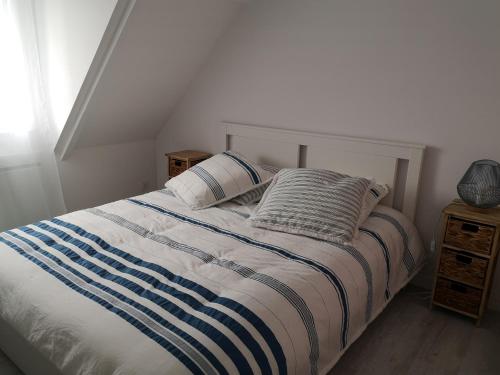a bedroom with a bed with two pillows on it at Les baigneurs in Merville-Franceville-Plage