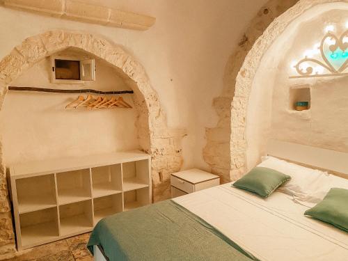 um quarto com uma cama num quarto com um arco em Trullo Bianco Ostuni em Ostuni