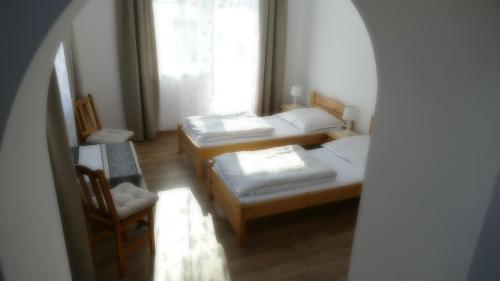 a room with three beds and a window at Apartamenty Bogusia Korbielów Pilsko in Korbielów