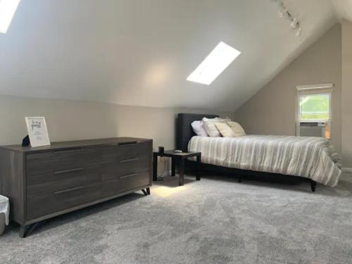 a bedroom with a bed and a dresser in a attic at Hyde Park Getaway - Close to Square & Downtown! in Cincinnati