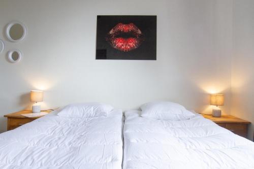 two beds in a bedroom with a painting on the wall at Dalasjö vandrarhem in Vilhelmina