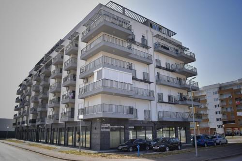 a tall building with cars parked in front of it at Apartman Dajana in Trebinje