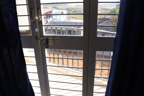 an open door with a view of a yard seen through it at Nature's Lap Homestay in Igatpuri