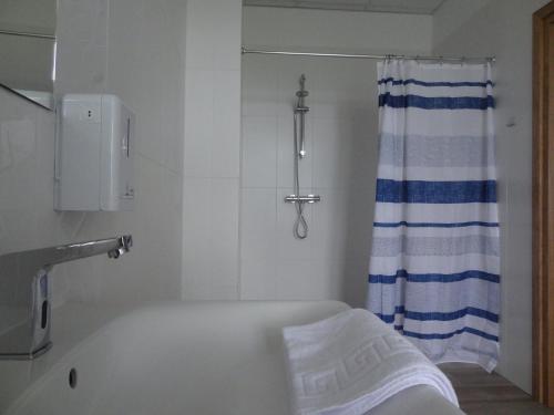 a bathroom with a tub and a shower curtain at DOMUS MARIAE Gietrzwałd in Gietrzwałd