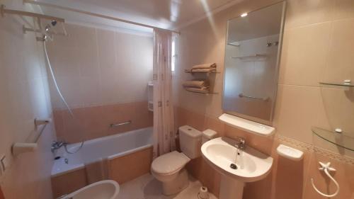 ein Badezimmer mit einem Waschbecken, einem WC und einem Spiegel in der Unterkunft Benidorm San Remo Tower Apartment in Benidorm