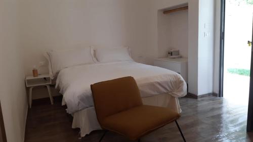 1 dormitorio con 1 cama blanca y 1 silla en Relais FraSimon Antico Casale, en San Vito Chietino