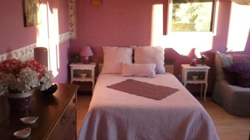 ein Schlafzimmer mit einem großen Bett mit einer weißen Decke in der Unterkunft Alain et Flo in Charancieu