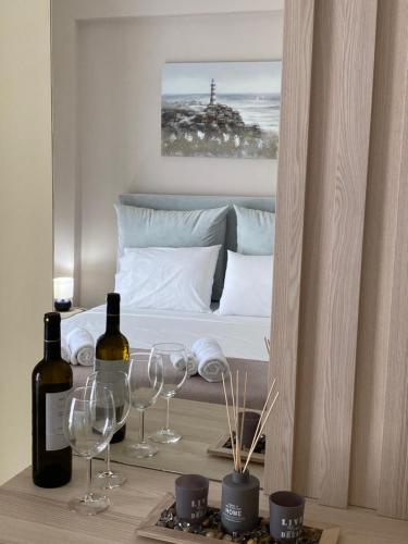 1 dormitorio con 1 cama con 2 copas y botellas de vino en Elizabeth Apartments Himare, en Himare