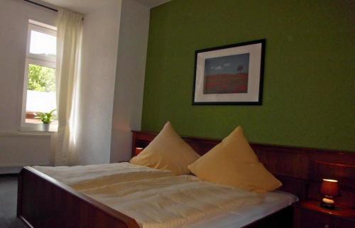 a bedroom with a bed with green walls and a window at Hotel garni am Thüringer KloßTheater in Friedrichroda