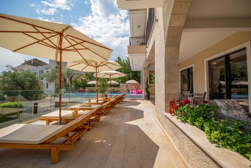 a row of tables with umbrellas next to a building at B&B Amfora in Petrovac na Moru
