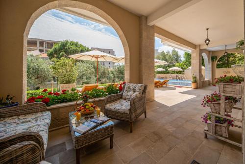 an outdoor patio with chairs and a table and an umbrella at B&B Amfora in Petrovac na Moru