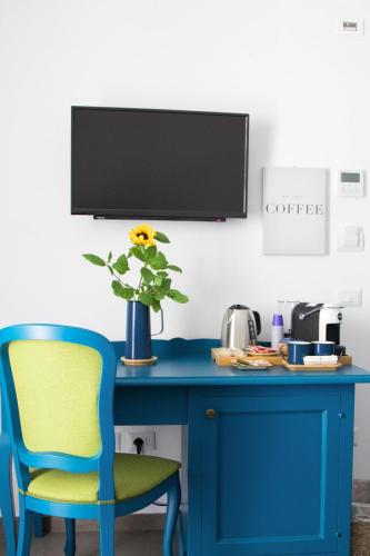 a blue desk with a blue chair and a vase with a flower at Isolotto Guest House in Porto Ercole