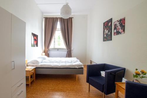 1 dormitorio con 1 cama, 1 silla y 1 ventana en Dalasjö vandrarhem, en Vilhelmina