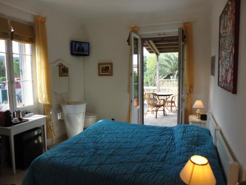 a bedroom with a blue bed and a door to a patio at Villa Playa del Sol - B1 in Saint-Tropez