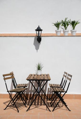 two chairs and a wooden table with a table with plants at Planeta Cadiz Hostel in Cádiz