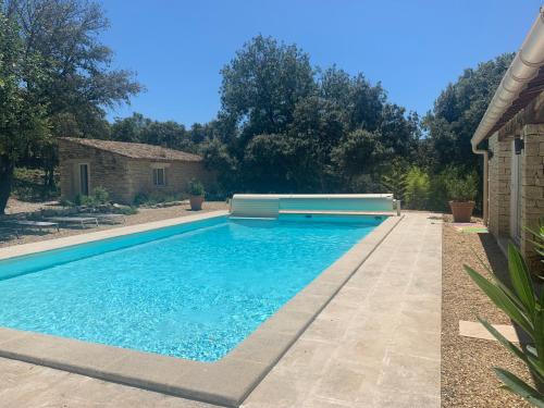 a swimming pool with blue water in a yard at Lou Mas in Gordes