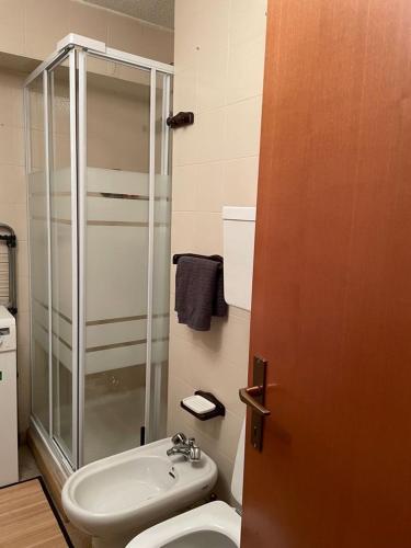 Un baño con ducha, inodoro y lavabo. en Be Smiling Apartment, en Passo del Tonale