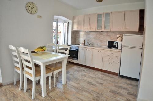 cocina con mesa y sillas blancas y nevera blanca en Bell Tower Apartment, en Budva