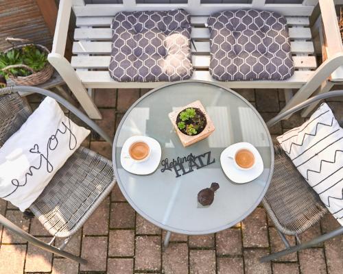 a table with two cups of coffee and a plate of food at Gästehaus J. Baumann in Rust