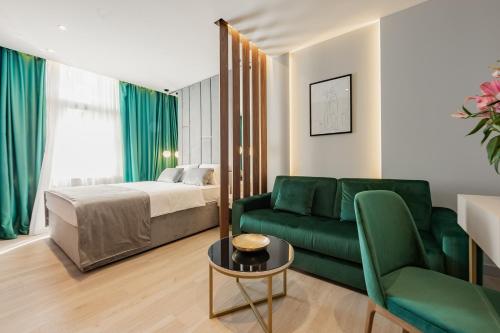 een woonkamer met een groene bank en een bed bij Caldo Luxury Rooms in Split