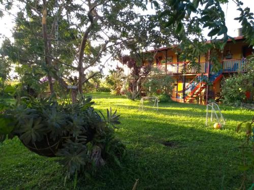 a yard with a house in the background at Hotel Alto de los Andaquies in San Agustín