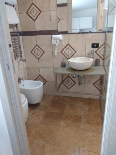 a bathroom with a toilet and a sink and a tub at Rainbow Sweet Rooms in Valmontone