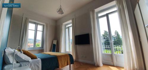 a bedroom with windows and a bed and a television at B&B La Corte Antica - Luino Lago Maggiore in Luino