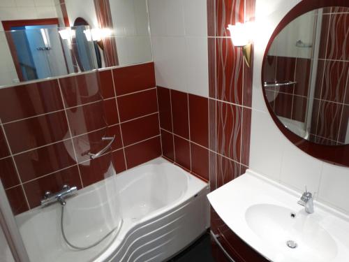 une salle de bain avec une baignoire, un lavabo et un miroir dans l'établissement Le Cèdre Bleu - GITE, à Châtenois