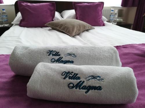 two towels on top of a bed with purple sheets at Villa Magna in Gdynia