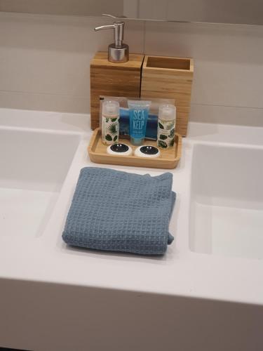 a tray of glasses and a sink with a blue pillow at Sunset Waves Benidorm by KalmaRent in Benidorm