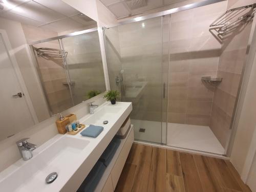 a bathroom with a white sink and a shower at Sunset Waves Benidorm by KalmaRent in Benidorm