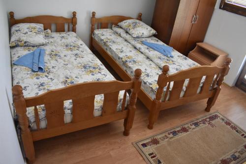 two twin beds in a bedroom with a rug at Šćekić Accommodation in Žabljak