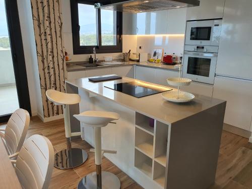 a kitchen with a large island with stools at Sunset Waves Benidorm by KalmaRent in Benidorm