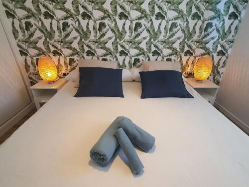 a bed with two blue pillows and two lamps on it at Sunset Waves Benidorm by KalmaRent in Benidorm