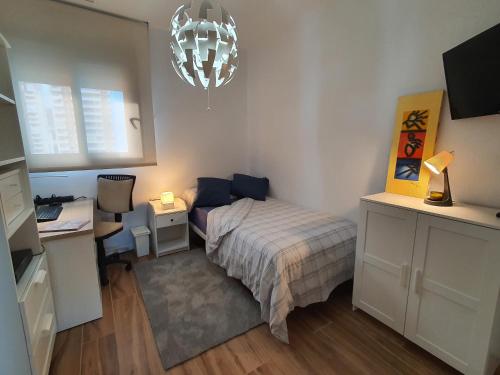 a small bedroom with a bed and a desk and a desk at Sunset Waves Benidorm by KalmaRent in Benidorm