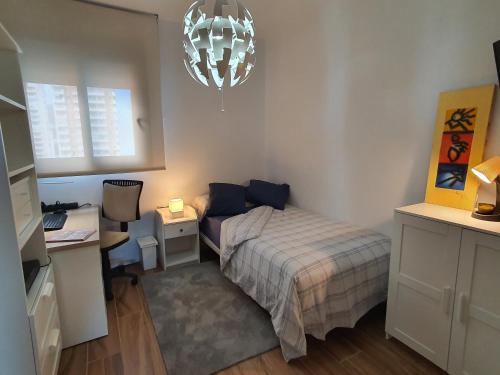 a bedroom with a bed and a desk and a lamp at Sunset Waves Benidorm by KalmaRent in Benidorm