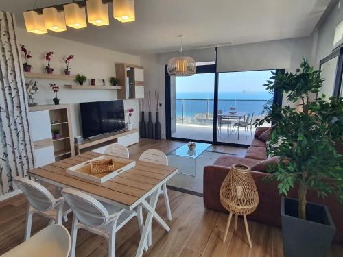 a living room with a table and a couch at Sunset Waves Benidorm by KalmaRent in Benidorm
