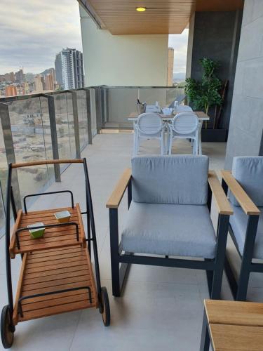 a chair and a table on a balcony at Sunset Waves Benidorm by KalmaRent in Benidorm