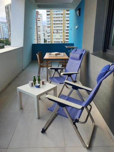 a room with two chairs and a table and a table at Sunset Waves Benidorm by KalmaRent in Benidorm