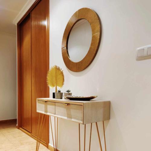 a mirror on a wall next to a table at Apartamento en Raxó in Pontevedra