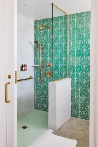 a bathroom with a shower with green and white tiles at RISE Uptown in Phoenix