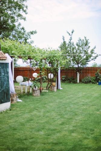 a backyard with a table and trees and a fence at Salaš Isailovi in Sremska Mitrovica