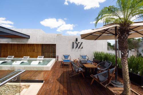 a patio with chairs and an umbrella and a pool at Diez Diez Collection in Mérida
