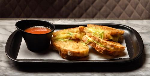 a black plate with toast and a cup of sauce at Diez Diez Collection in Mérida