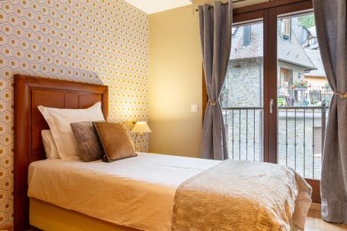 - une chambre avec un lit et une grande fenêtre dans l'établissement APARTAMENTO NETÚ, à Bossost